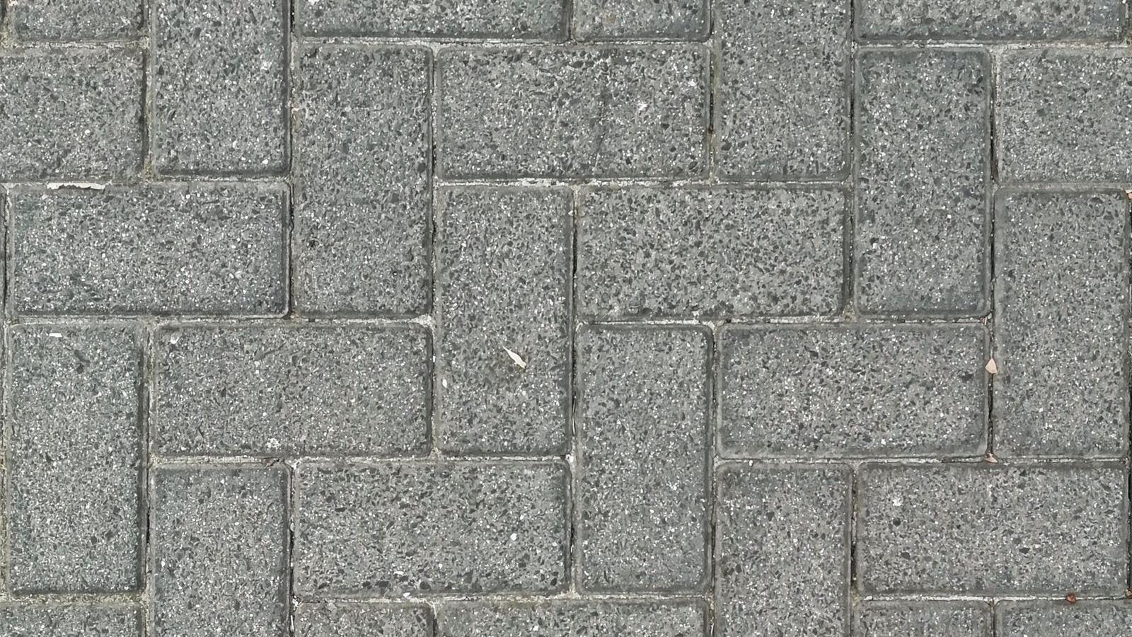 Gray interlocking concrete pavers laid in a herringbone pattern