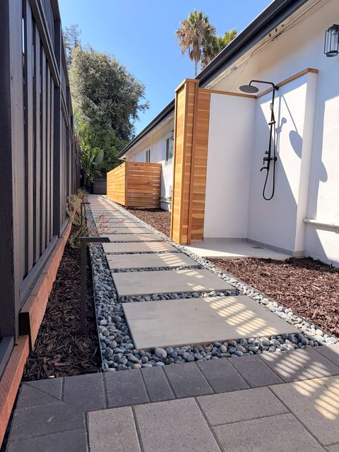 Stepping-stone walkway with pebble borders leading to the outdoor shower area
