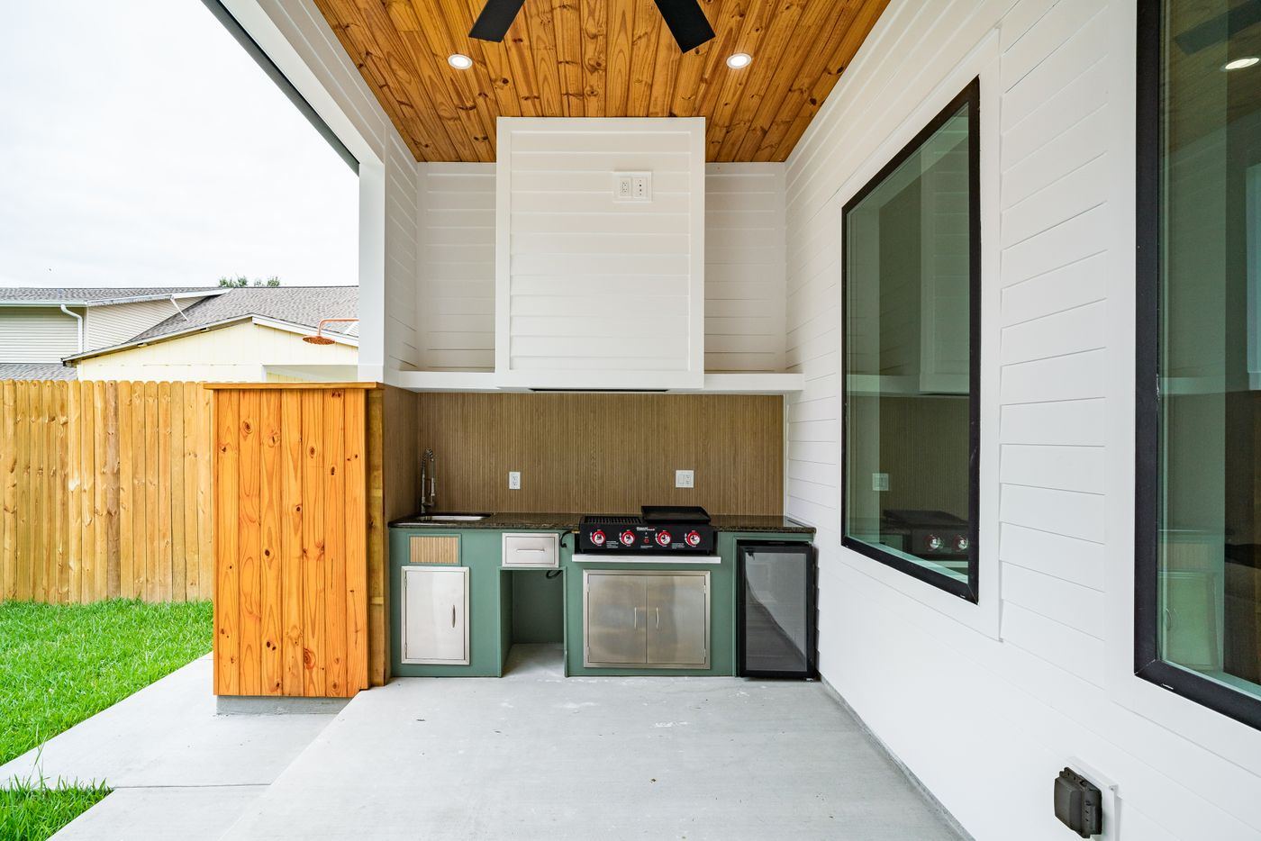 Covered outdoor kitchen with a built-in grill, counter and refrigerator